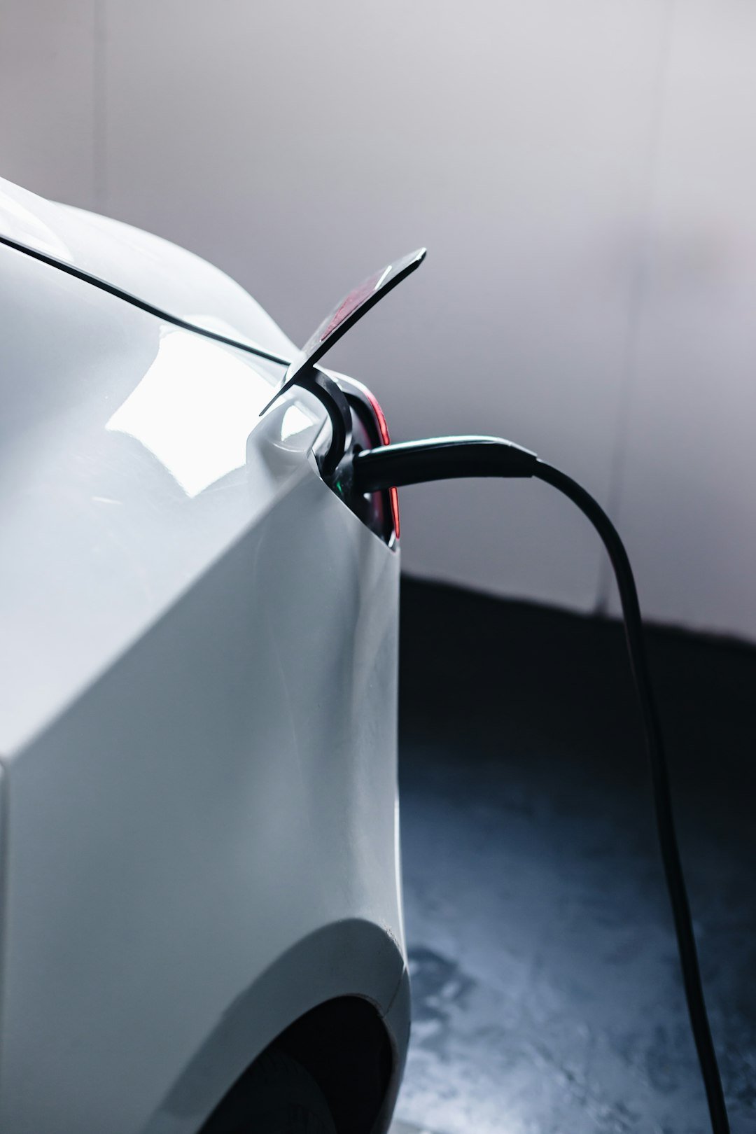 a-white-car-is-plugged-in-to-a-charger-ksag1eyq2uy